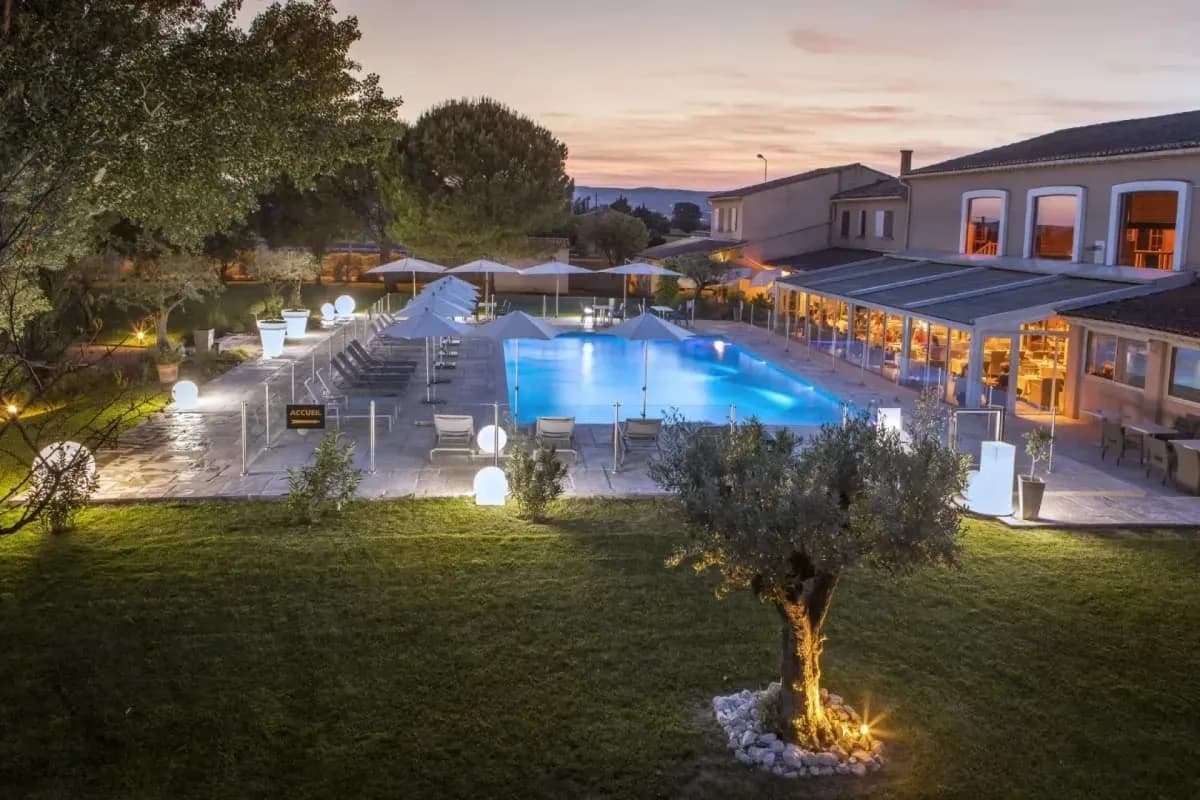 Le Domaine des Oliviers à Pierrelatte, avec son jardin et sa piscine à la tombée du jour